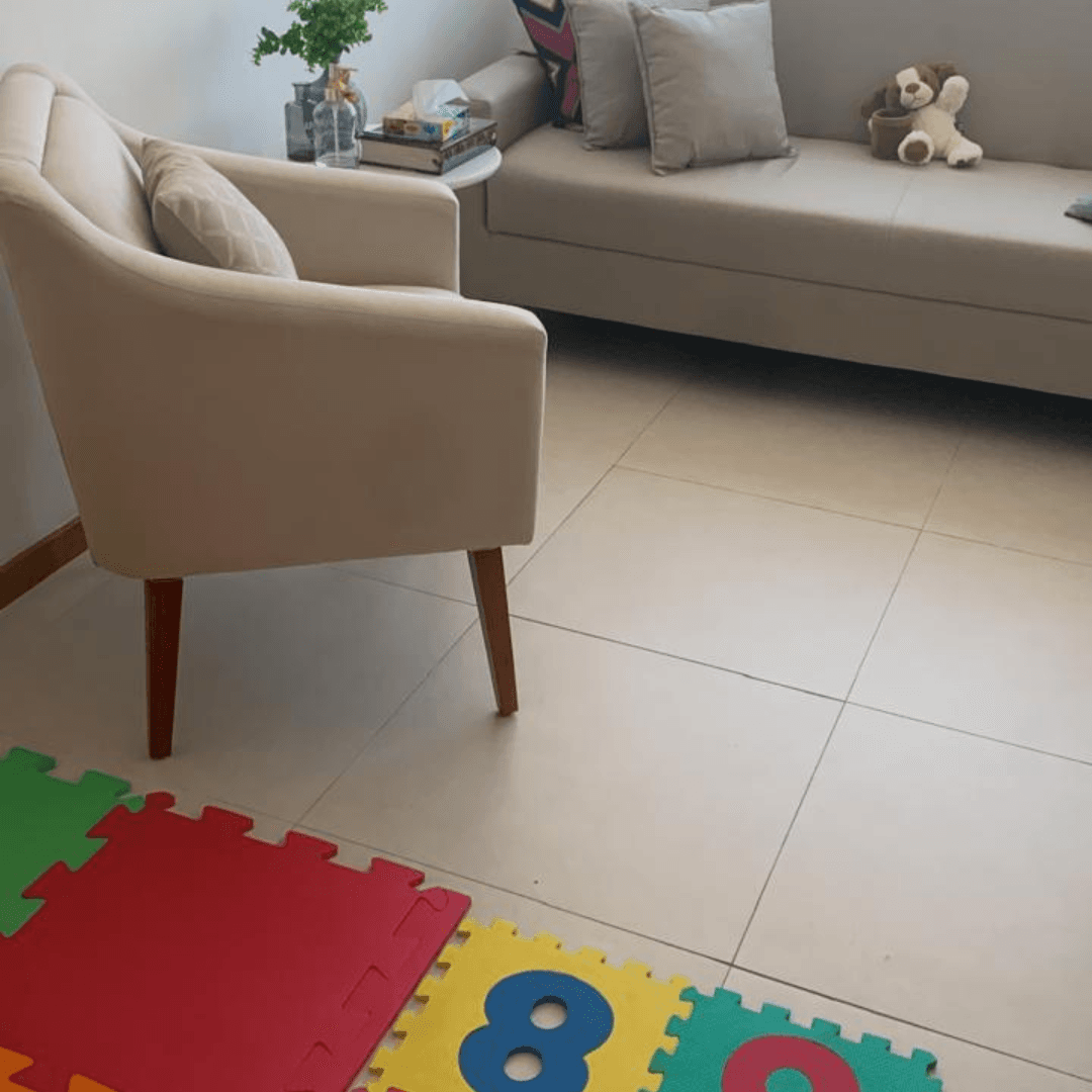 Espaço terapêutico infantil com brinquedos e poltronas